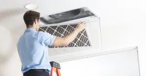 Technician cleaning air duct.