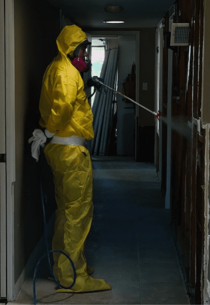person in hazmat suit professionally sanitizing