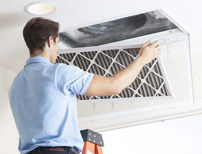 a man checking the vents on a ceiling