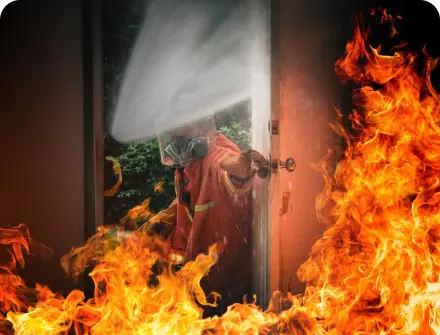 A firefighter putting out a house fire