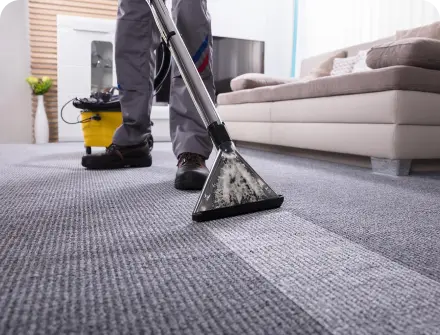 A worker cleaning a carpet